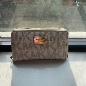 A Michael Kors cream wallet with the classic MK logo.